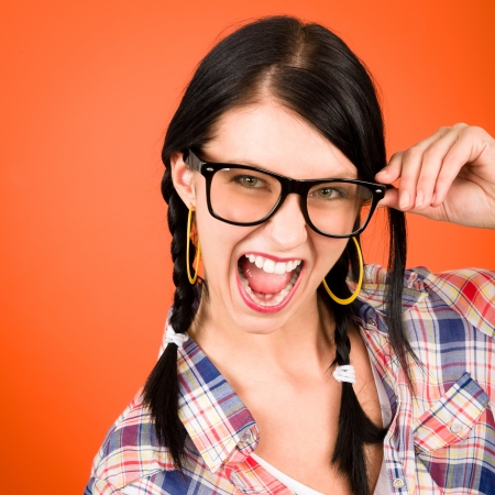 Crazy girl wear nerd glasses shouting on orange backgroundの写真素材