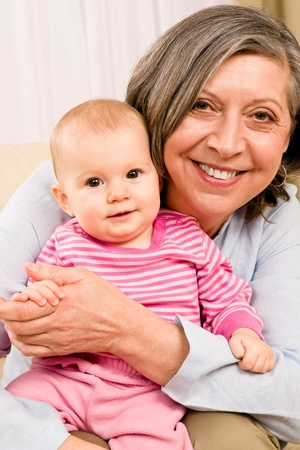 Senior woman hold little baby girl cute smiling close-upの写真素材