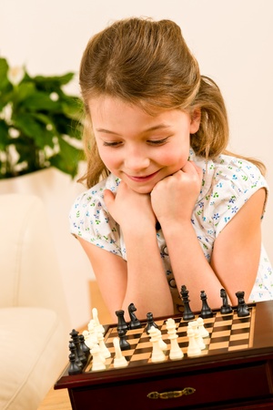 Young girl play chess cute smile alone at homeの写真素材