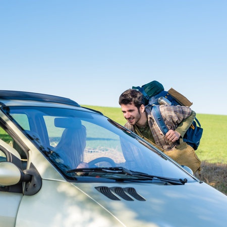 Hitch-hiking getting lift young woman in car road trip
