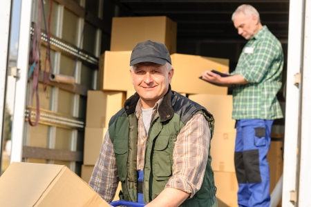 Male mover loading van with cardboard box delivery serviceの写真素材
