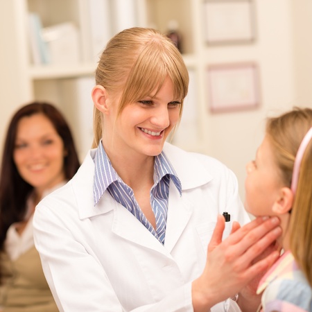 Little girl having throat examination by pediatrician using light penの写真素材