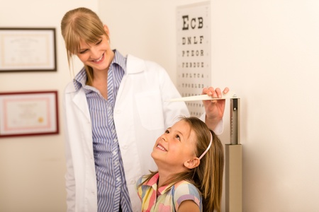 Pediatrician measure height of little girl at medical officeの写真素材