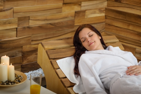 Young woman relaxing on wooden chair at luxury spaの写真素材