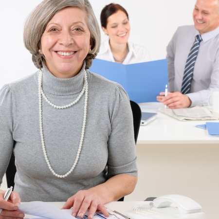 Young executive woman hold report sitting at office with colleaguesの写真素材