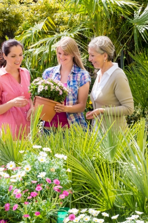 Three woman shopping potted flowers at garden centre green houseの写真素材