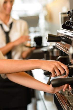 Close up hands waitress make coffee at work espresso machineの写真素材