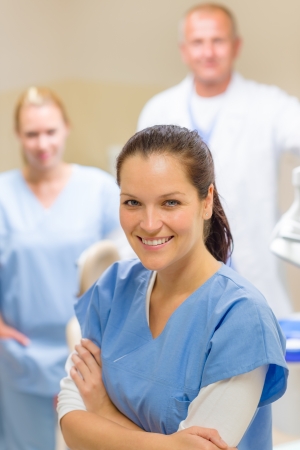 Smiling dental hygienist woman with stomatology team of medical professionalsの写真素材