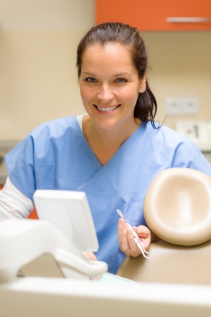 Smiling dentist woman prepare dental tools at modern surgery officeの写真素材