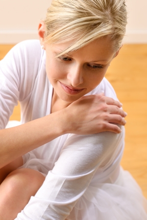 Beautiful ballerina rests sitting on studio floor woman ballet happyの写真素材