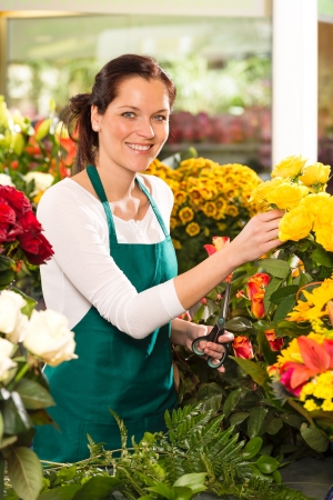 Cheerful woman flower shop market choosing working colorful marketの写真素材