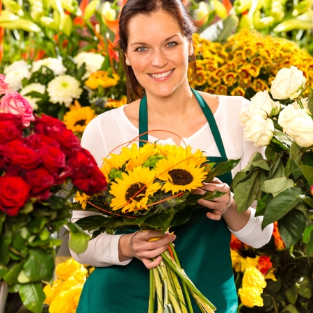 Smiling florist woman bouquet sunflowers flower shop colorful showingの写真素材