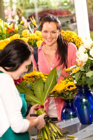 Cheerful woman buying bouquet flower shop florist cutting marketの写真素材