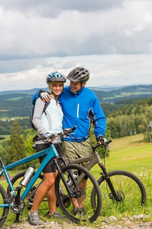 Young cuddling cyclists with mountain bikes during summer weekendの写真素材