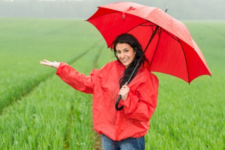 Elated smiling girl during rainy weather outside with umbrellaの写真素材
