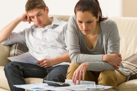 Annoyed couple calculating their finances during recessionの写真素材