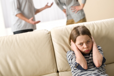 Parents fighting in front of their unhappy daughter childの写真素材