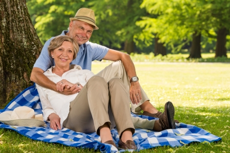 Cheerful pensioners hugging and relaxing outdoors sunny parkの写真素材