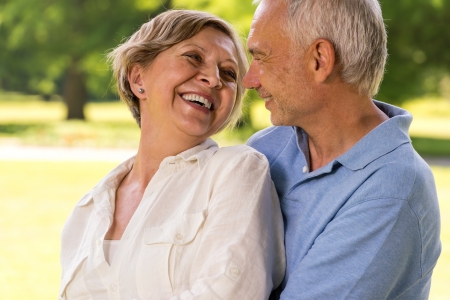 Happy retirement senior couple hugging and smiling at each otherの写真素材