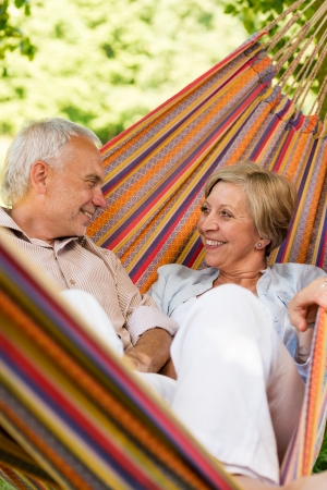 Happy elderly couple lying in hammockの写真素材