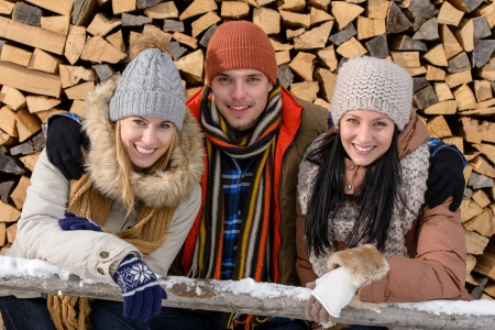 Young people in winter clothes posing outside wooden logs countrysideの写真素材