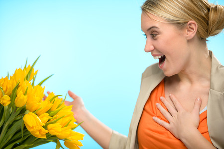 Surprised woman receive bouquet of yellow tulip flowers springの写真素材