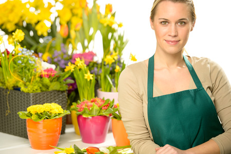 Florist with spring potted flowers colorful looking at cameraの写真素材