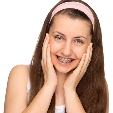 Happy girl with braces teenage beauty on white backgroundの写真素材