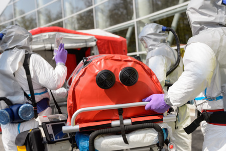 Biohazard medical team pushing stretcher towards decontamination chamberの写真素材
