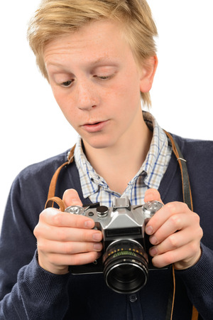 Teenage boy using retro camera against white backgroundの写真素材