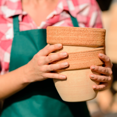 Close-up of garden center worker hands holding two clay potsの写真素材