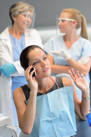 Busy businesswoman patient calling phone at dentist office doctor waitingの写真素材