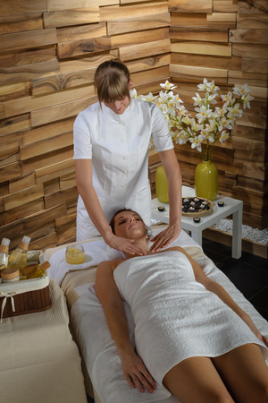 Young therapist massaging cleavage to attractive  woman at spaの写真素材
