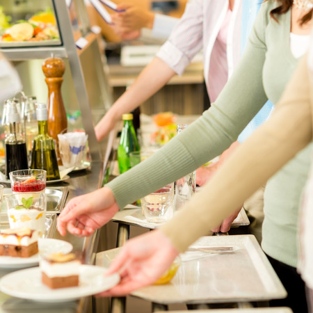 Desserts at cafeteria people with serving tray self service canteenの写真素材