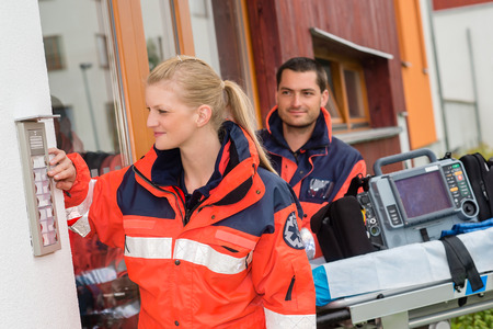 Paramedics house call visit ambulance help ringing woman man assistanceの写真素材
