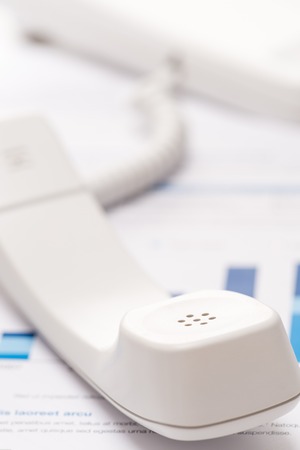 Business telephone headset white close-up unhung on office deskの写真素材