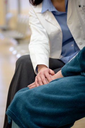 Doctor holding senior patient hands in hospitalの写真素材