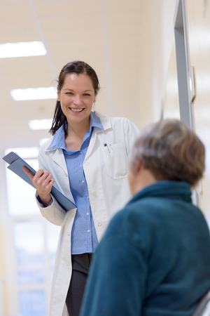 Female doctor smiling to senior patient in hospitalの写真素材