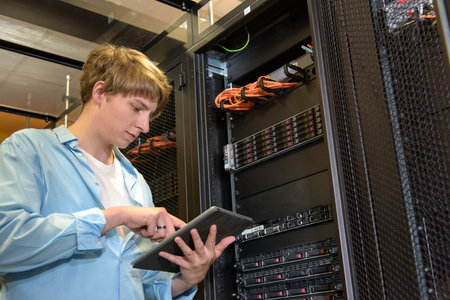 IT specialist configuring servers in climate controlled datacenter