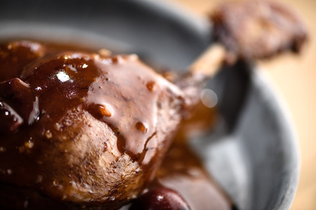 Roasted duck leg covered with red port wine cherry sauce in tin plateの写真素材