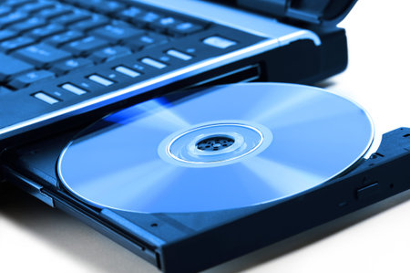 compact disk inserted on notebook drive, on white background