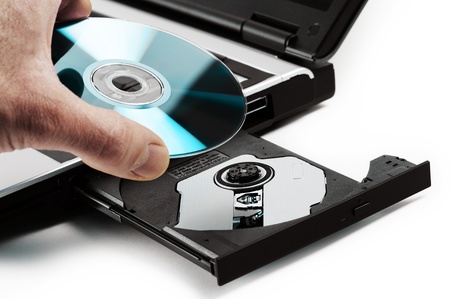 compact disk inserted on notebook drive, on white backgroundの写真素材