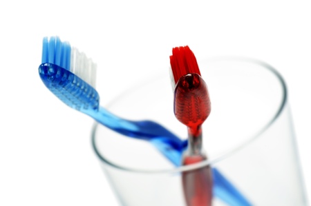 pair of toothbrushes in a glass, on white backgroundの写真素材