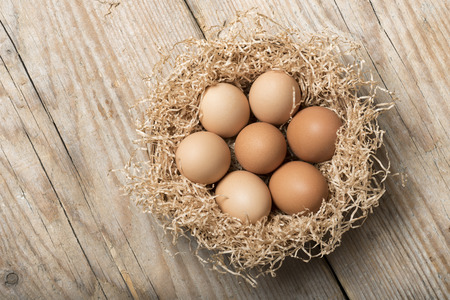 group of eggs in straw basket on wooden table