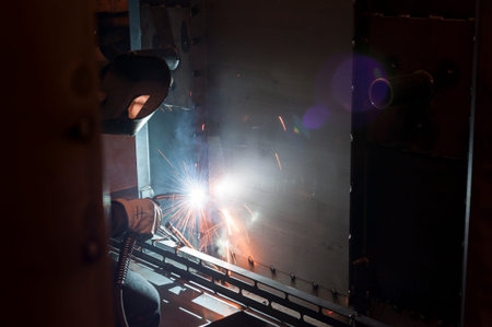 Welder uses torch to welding during manufacture of metal equipment.