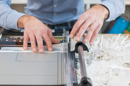 man cutting print with precision cutterの写真素材