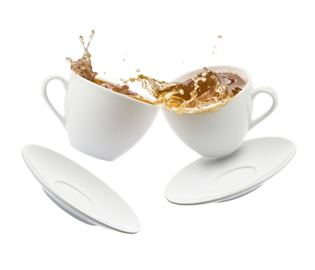two cup of tea jumps and clash with splashing on white backgroundの写真素材