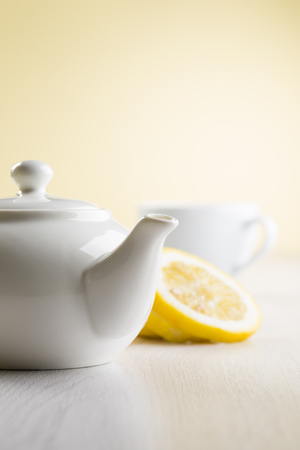 white teapot on table with lemon slicesの写真素材