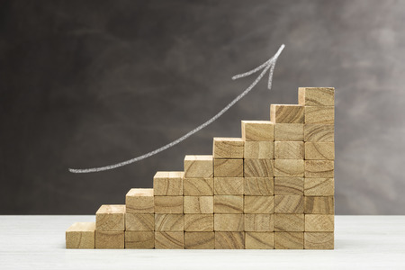 Concept of growth. Graphic with wooden steps on grey background with arrow drawn.の写真素材
