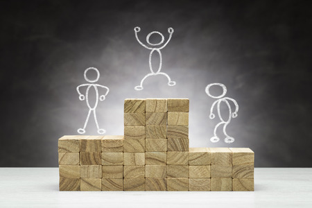Concept of competition. Wooden podium on grey background with people shapes.の写真素材